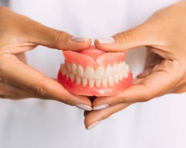 Lady presents viewer with denture