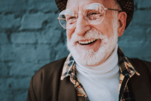 Stylish man smiling on blue-brick background